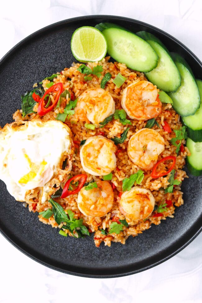 Closeup of black plate with spicy fried rice with shrimp.