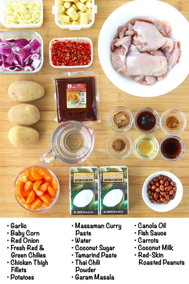 Labeled ingredients for Massaman chicken curry on a wooden board.