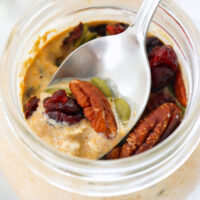 Pumpkin overnight oats in a jar and closeup of spoon with in jar with toppings. Text overlay "Pumpkin Spice Overnight Oats", "High Protein | Easy | Healthy | Meal Prep", and "thatspicychick.com".