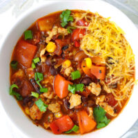 Chicken chili in a bowl. Text overlay "Spicy Ground Chicken Chili" and "thatspicychick.com".