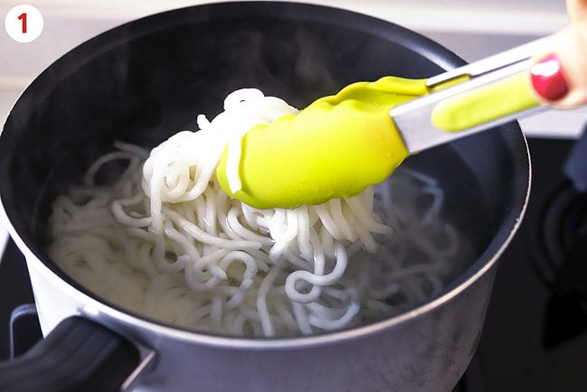 Noodle cakes in pot and using tongs to gently shake a noodle cake to loosen strands.