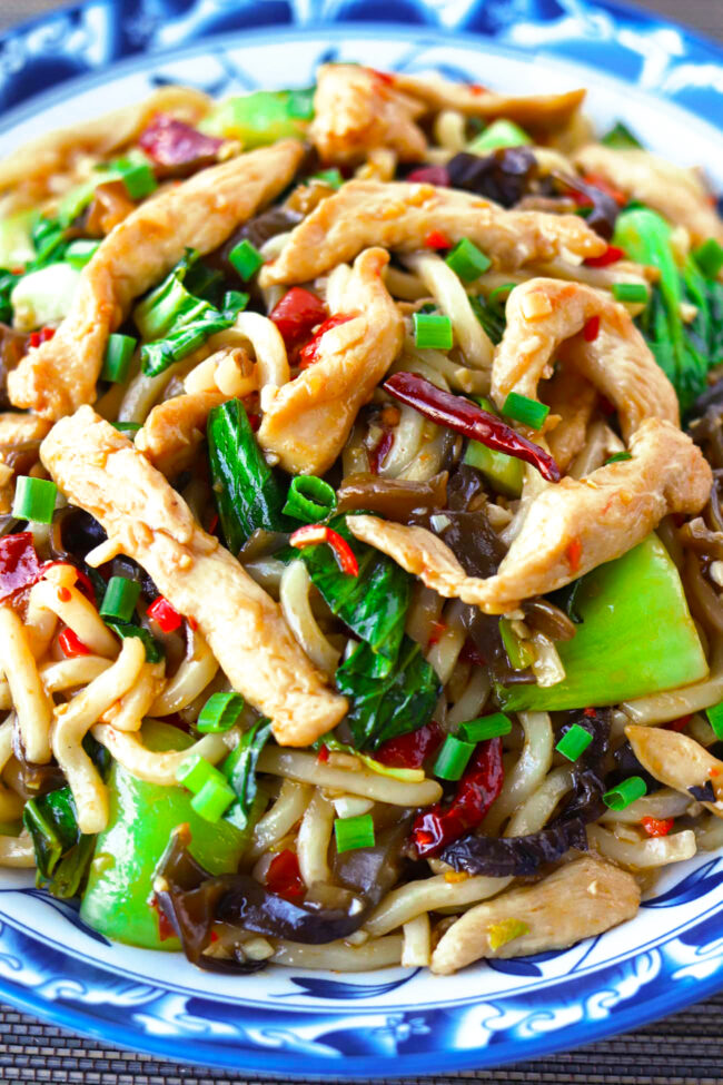 Closeup front view of chili garlic chicken noodles stir-fry on a plate.