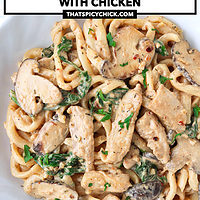 Close-up of cream sauce noodles with mushrooms and chicken on a plate. Text overlay "Creamy Mushroom Udon with Chicken" and "thatspicychick.com".