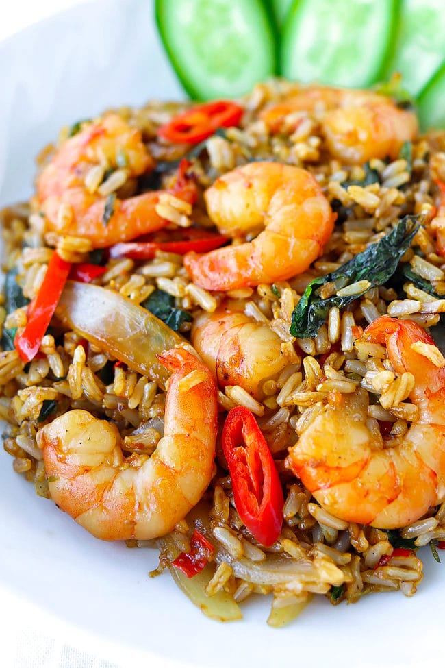 Closeup front view of Thai holy basil shrimp fried rice on a plate.