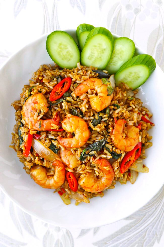 Thai basil shrimp fried rice on a plate with cucumber slices.