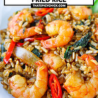 Closeup of shrimp fried rice on a plate. Text overlay "Spicy Thai Basil Shrimp Fried Rice" and "thatspicychick.com".
