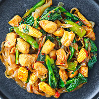 Black plate with Thai stir-fried noodles with chicken. Text overlay "Shirataki Drunken Noodles" and "thatspicychick.com".