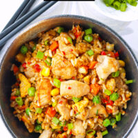 Bowl with fried rice and chopsticks on the side. Text overlay "Spicy Chicken Fried Rice" and "thatspicychick.com".
