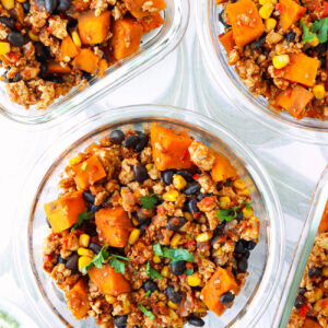 Mexican ground chicken, sweet potato, black beans, corn garnished with coriander in meal prep containers.