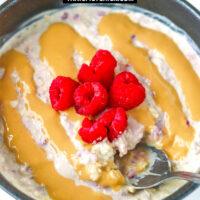 Spoon in bowl with overnight oats. Text overlay "Salted Caramel Raspberry Overnight Oats" and "thatspicychick.com".