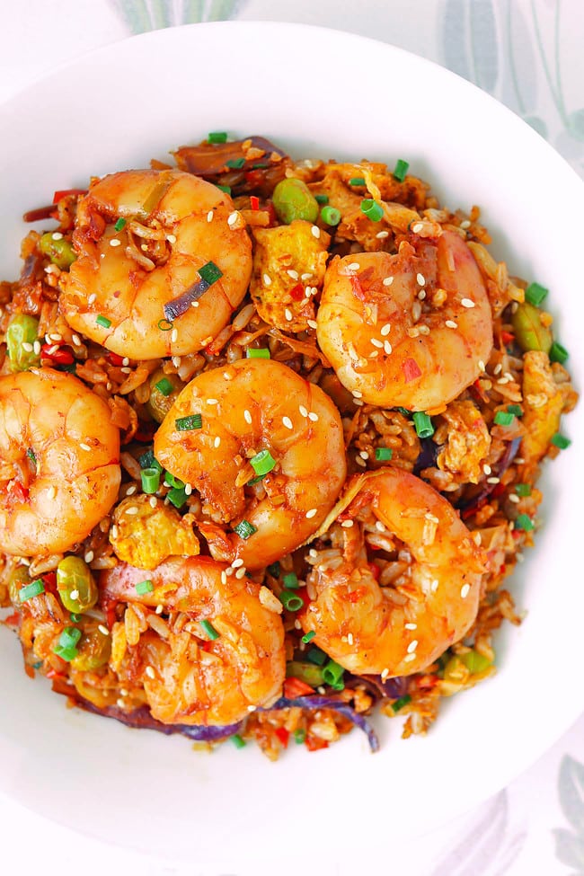 Closeup top view of plate with Korean gochujang fried rice with jumbo shrimp.