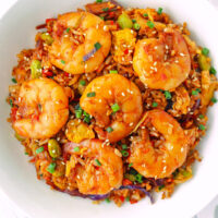 Fried rice with large shrimp on a plate. Text overlay "Gochujang Fried Rice with Jumbo Shrimp" and "thatspicychick.com".