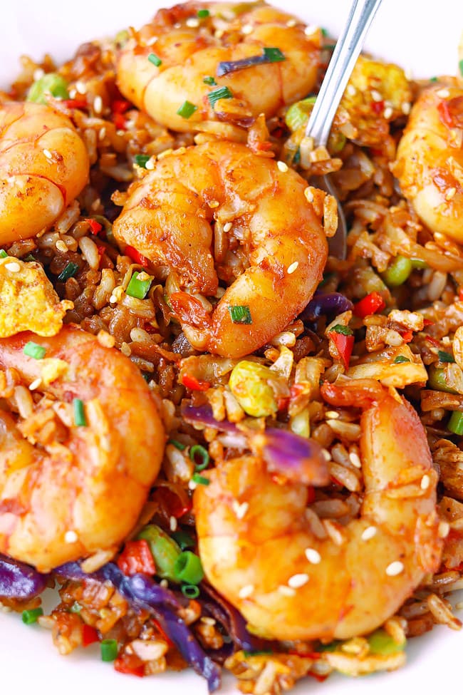 Spoon in plate with Korean shrimp fried rice.