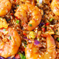 Spoon in plate with shrimp fried rice. Text overlay "Korean Gochujang Fried Rice" and "thatspicychick.com".