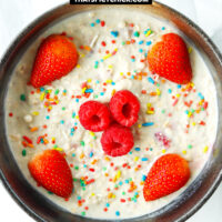 Overnight oats in a bowl with sprinkles and berries. Text overlay "Birthday Cake Overnight Protein Oats" and "thatspicychick.com"
