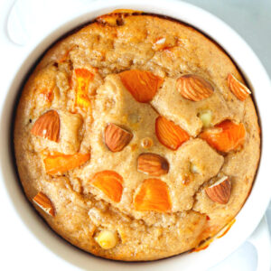 Closeup top view of Apricot Almond Baked Oats in a white ramekin with handles.