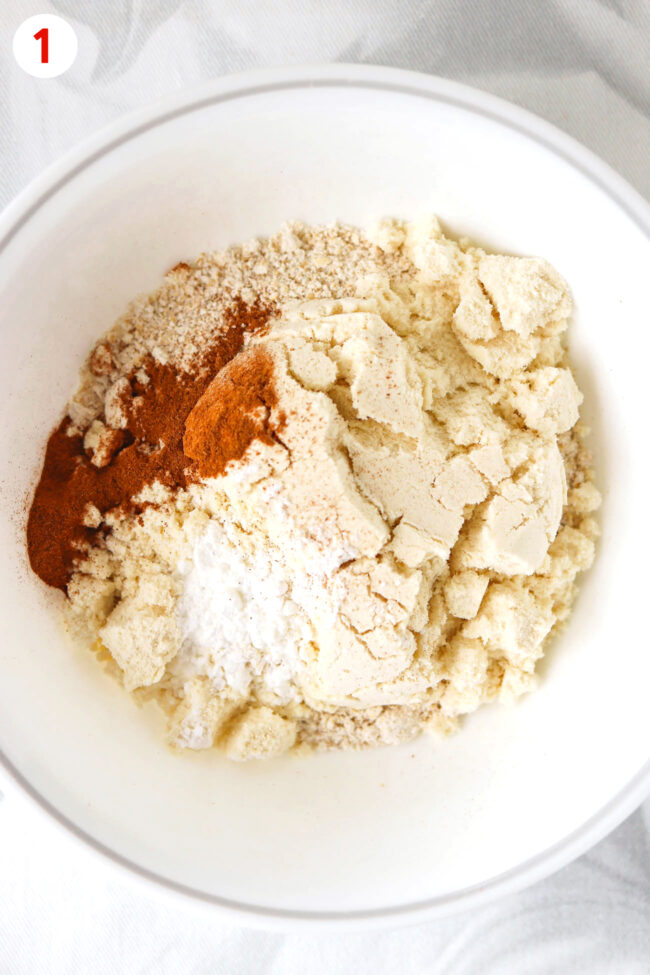 Blended oats, ground cinnamon, protein powder and baking powder in a bowl.