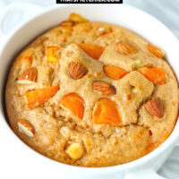 Closeup front view of baked oats in a white ramekin. Text overlay "Apricot Almond Baked Oats" and "thatspicychick.com".