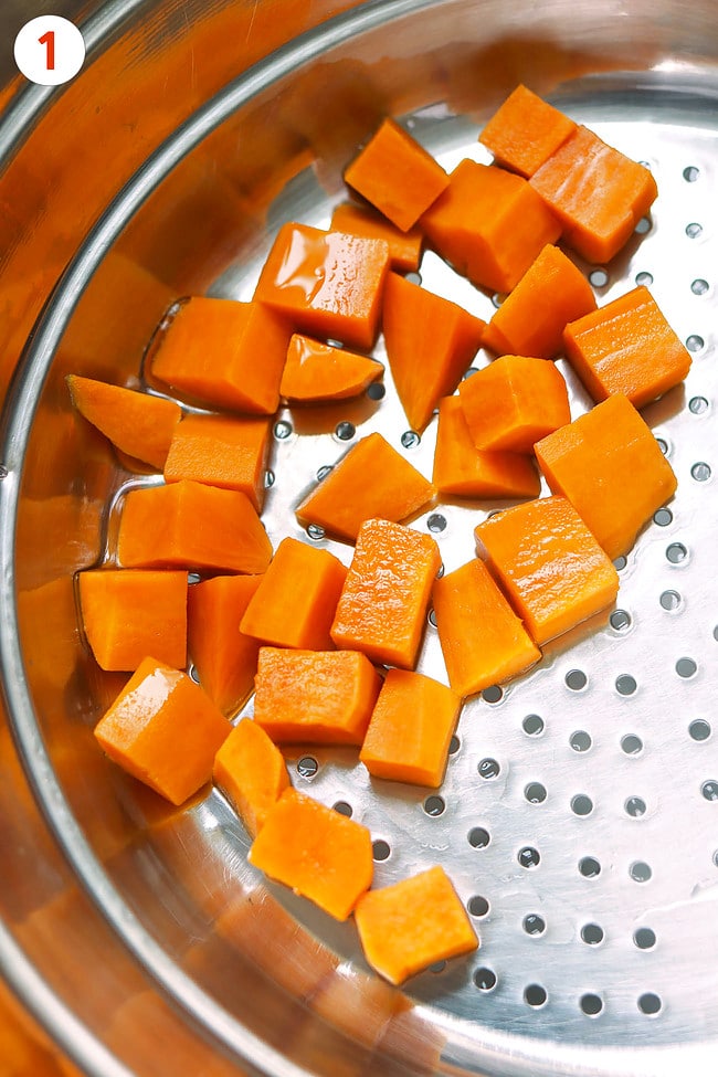 Parboiled diced sweet potatoes in a colander.