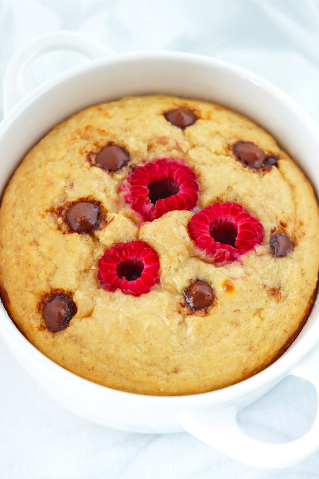 Closeup front view of raspberry chocolate chip baked oats in a ramekin with handles.