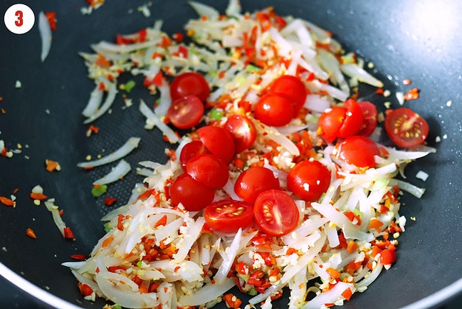 Added halved cherry tomatoes to wok with stir-fried onion, garlic and chilies.