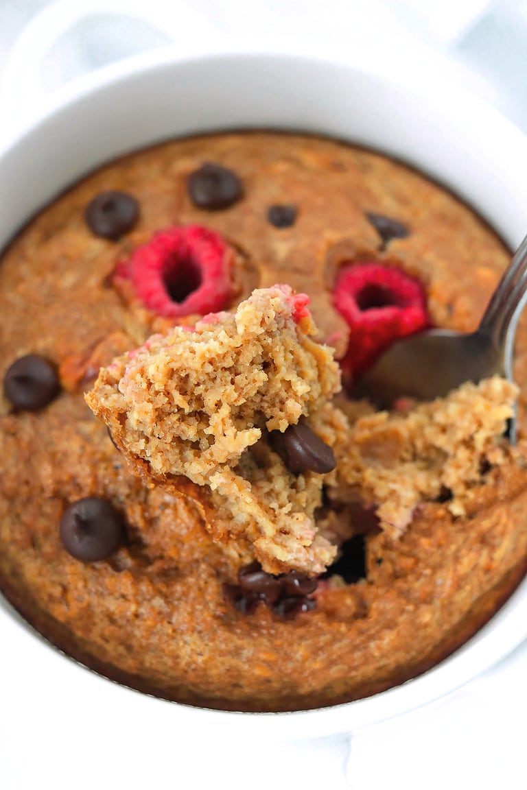 Spoon with a bite of baked oats in a ramekin to show inside cake-like texture.