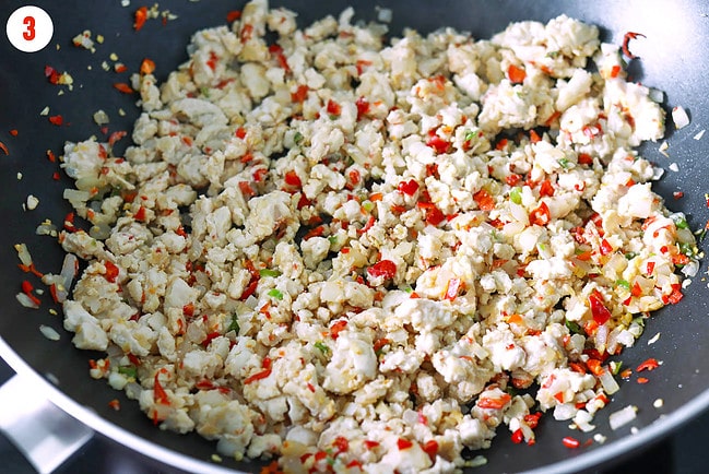 Cooked ground chicken combined with chilies, garlic and onion in a wok.