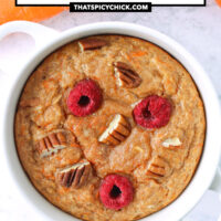 Top view of baked oats in a ramekin and carrots in the background. Text overlay "Carrot Cake Baked Oats" and "thatspicychick.com".