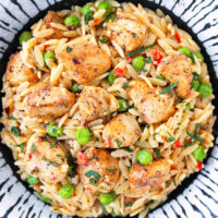 Closeup of plate with chicken orzo. Text overlay "Creamy Lemon Chicken Orzo" and "thatspicychick.com".