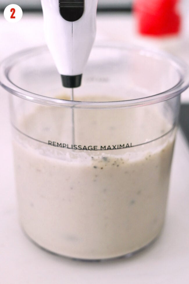 Using frother to bend cookies and cream protein ice cream mixture in Ninja Creami pint.