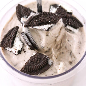 Spoon in pint of oreo ice cream topped with oreos made in a Ninja Creami.