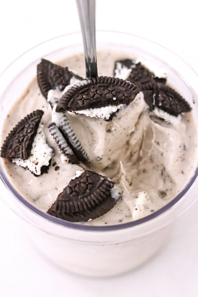 Spoon in pint of oreo ice cream topped with oreos made in a Ninja Creami.