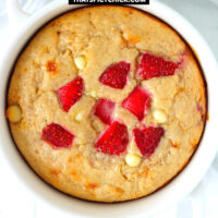 Closeup top view of baked oats with strawberries in a ramekin. Text overlay "Strawberry Cheesecake Baked Oats" and "thatspicychick.com".