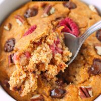 Spoon digging up a bite of pumpkin spice baked oatmeal. Text overlay "Pumpkin Baked Oats", "Single Serving + High Protein", and "thatspicychick.com".