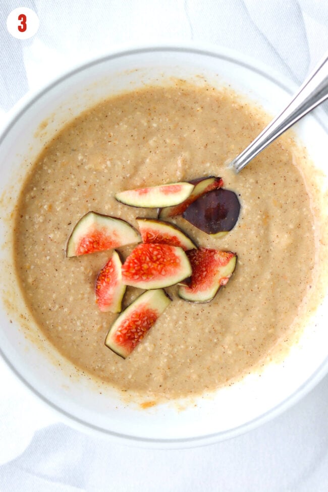 Batter for almond butter baked oats in a bowl topped with fig slices.