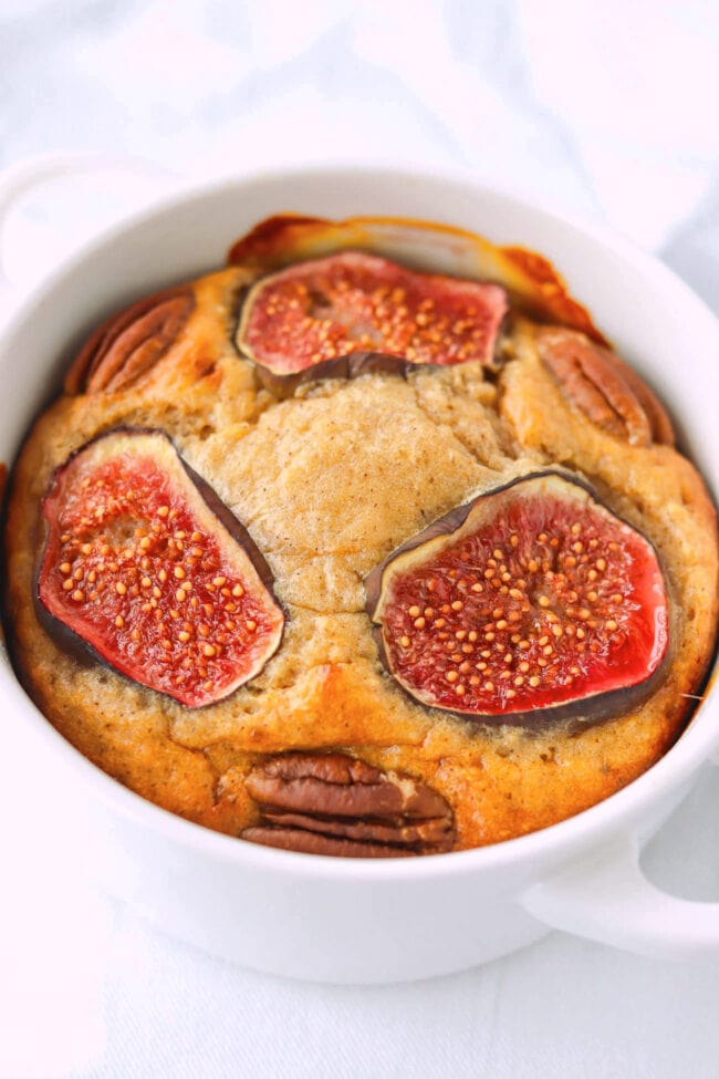 Closeup front view of ramekin with almond butter baked oats with figs.