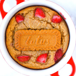 To view of Biscoff baked oats with strawberries in a ramekin.