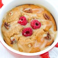 Closeup front view of cinnamon roll baked oats with sweetened condensed milk glaze in a ramekin.
