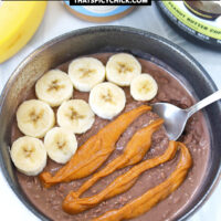 Chocolate overnight oats topped with banana slices and peanut butter in a bowl with spoon. Text overlay "Chocolate Peanut Butter Banana Overnight Oats" and "thatspicychick.com".