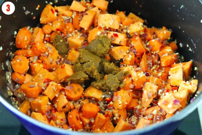 Added yellow curry paste to pot with carrots, onion, sweet potatoes, garlic, ginger and chilies.