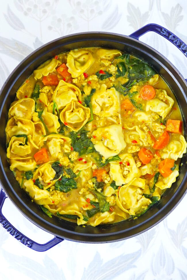 Thai yellow curry tortellini soup in a Dutch oven.