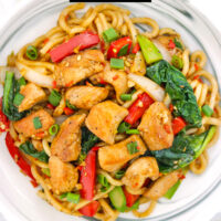 Closeup of plate with noodles stir-fry dish. Text overlay "Stir Fried Black Pepper Chicken Noodles" and "thatspicychick.com".