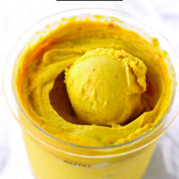 Yellow ie cream scoop in a pint with ice cream. Text overlay "Golden Milk Ice Cream Ninja Creami" and "thatspicychick.com".