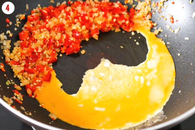 Poured beaten egg into wok with stir-fried veggies and aromatics.