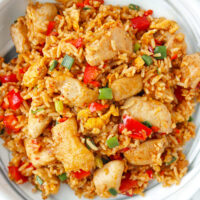 Closeup of sambal fried rice on a marble plate. Text overlay "Sambal Fried Rice with Chicken" and "thatspicychick.com".