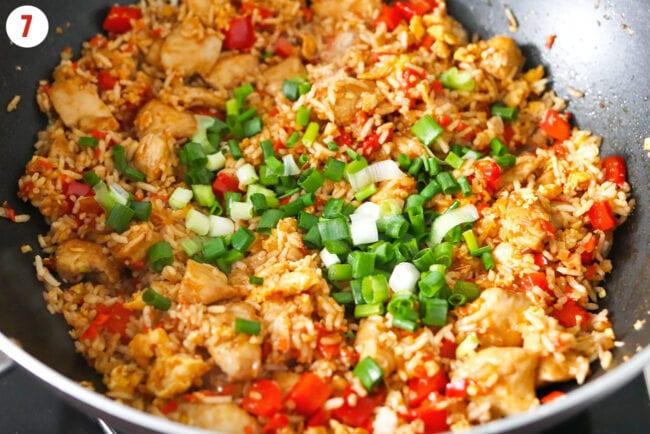 Added spring onion to wok with spicy fried rice with chicken.