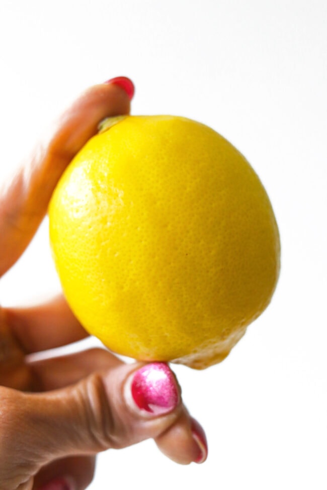 Hand holding up a lemon.