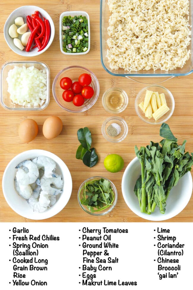 Labeled ingredients for tom yum fried rice on a wooden board.