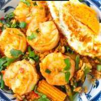 Spoon in plate with shrimp fried rice. Text overlay "Thai Tom Yum Fried Rice with Shrimp" and "thatspicychick.com".