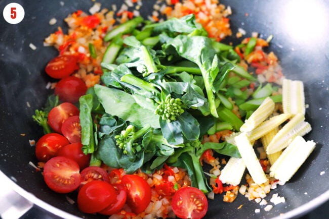 Added cherry tomatoes, Chinese broccoli and baby corn to wok with aromatics.